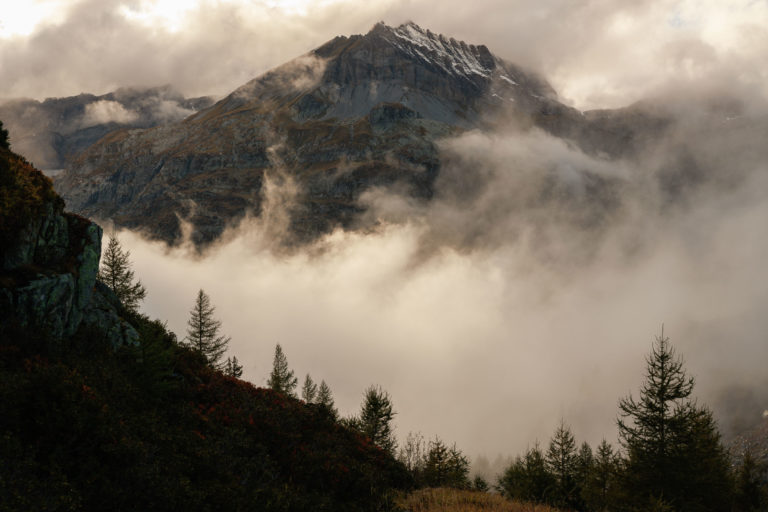 Pointe de la Finive au-dessus du lac d’Émosson, enveloppée de brumes vespérales et de couleurs automnales. Photographie d’Alexandre Deschaumes.