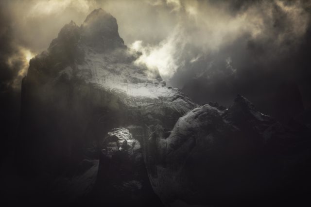 Né de l'Abysse Photographie d’Alexandre Deschaumes – Cuernos del Paine, parc Torres del Paine au Chili. Ambiance mystique et puissante, montagnes sombres éclairées par la lumière dramatique.